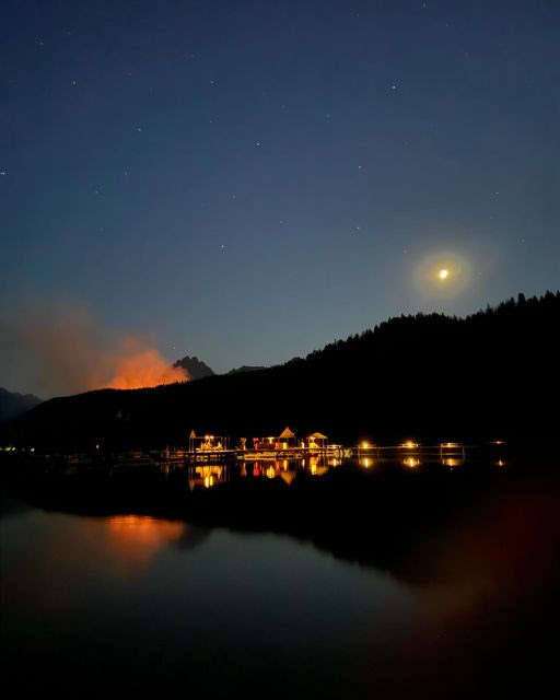Image of Redfish Lodge at night on 7/11/2024 with Bench Lake Fire Flames visible, Courtesy Redfish Lodge FB feed.